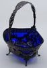Silver and cobalt-blue glass basket viewed from another angle, showing the ornate handle and splayed feet.