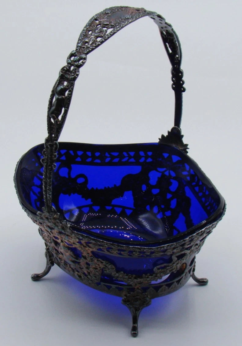 Silver and cobalt-blue glass basket viewed from another angle, showing the ornate handle and splayed feet.