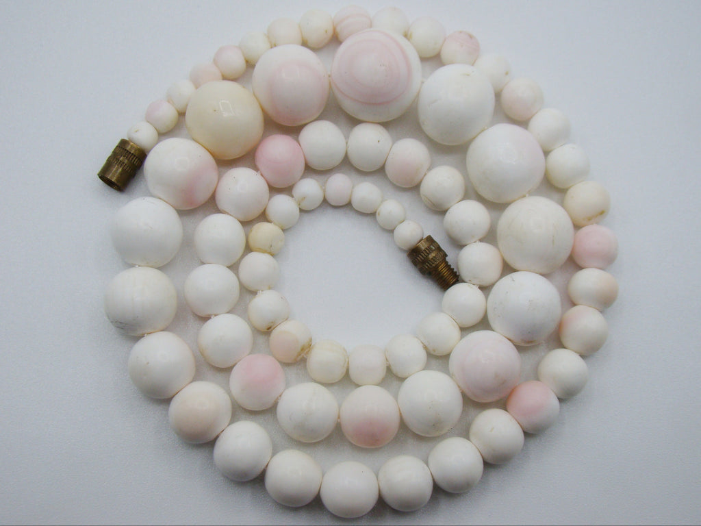 1930s White Angel Skin coral necklace arranged in a coil, showing graduated white and blush-pink beads