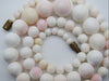 Detail of graduated white and pink coral beads showing surface texture and colour variation