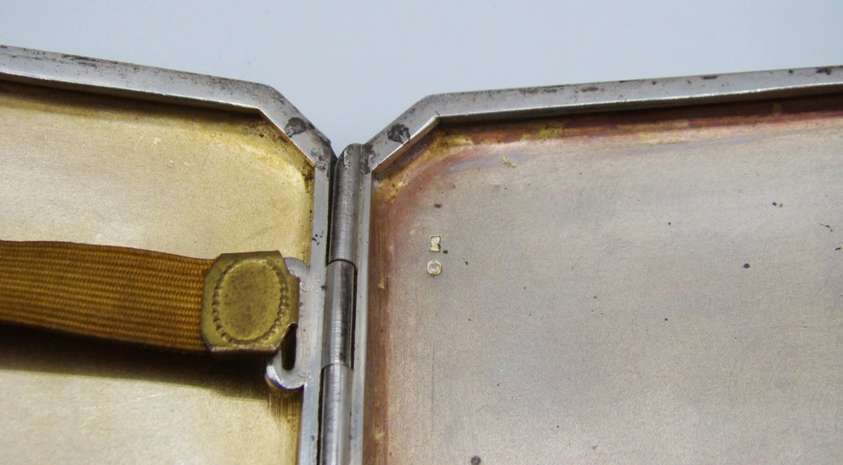 Close-up of the interior hinge, retaining strap attachment and small stamped marks.