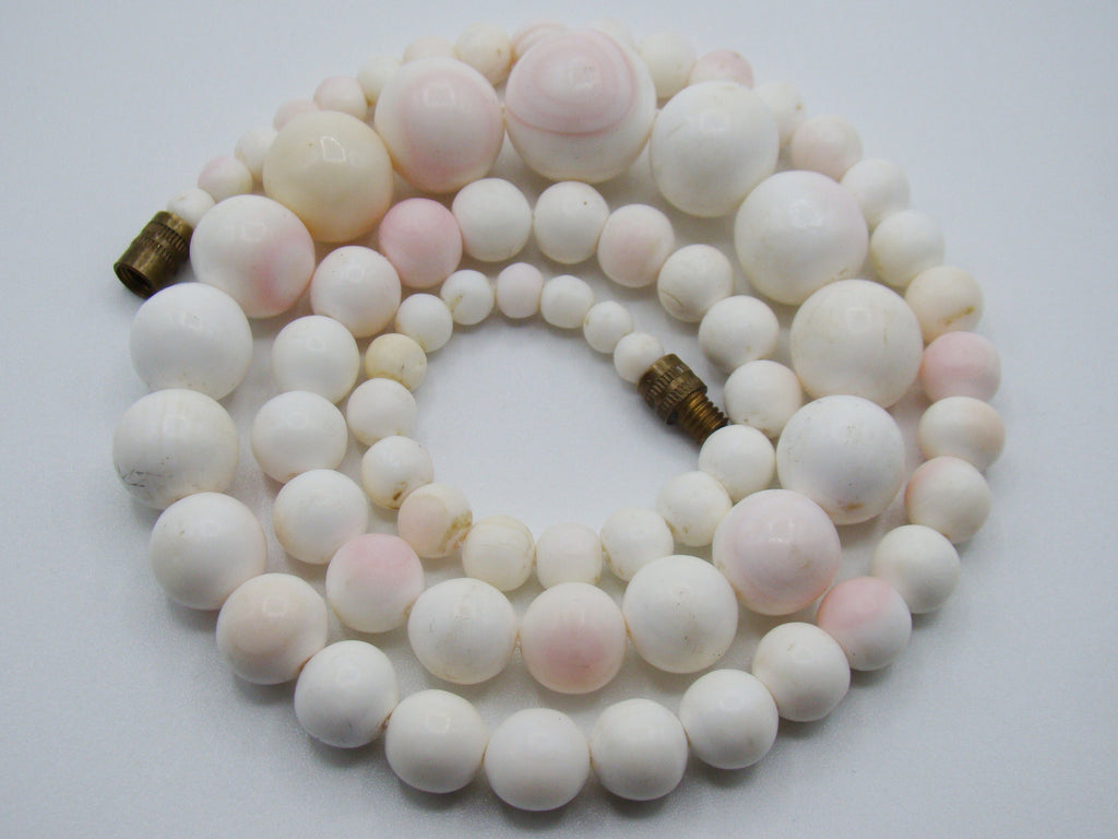 Full coiled view of the White Angel Skin coral necklace on a light background