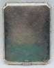 Plain silver reverse of the cigarette case showing surface scratches, patina and clipped corners.