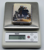 Decorated silver cigarette case on a digital scale displaying a total weight of 184 grams.