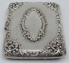 Alternate view of the silver cigarette case showing scrolling corner decoration, cartouche and stamped marks.