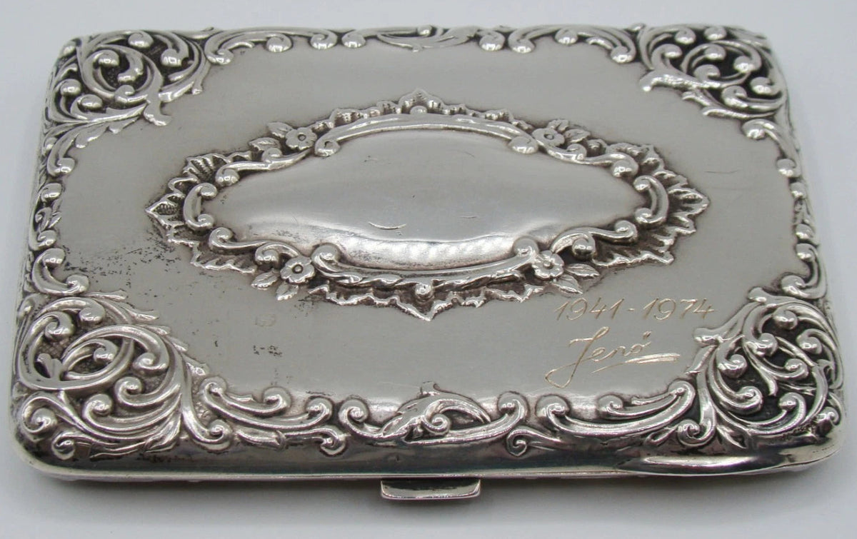 Decorated silver case panel with an oval cartouche, engraved dedication and dates, with visible surface wear.