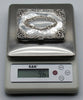Silver cigarette case on a digital scale displaying a total weight of 96 grams.