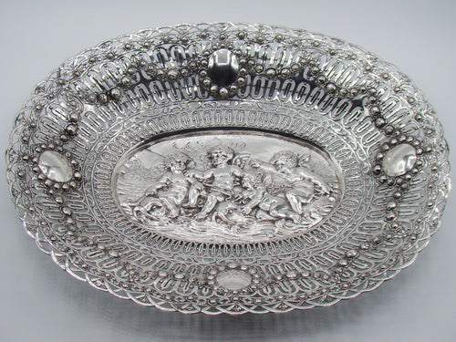 Overall view of an oval Baroque-style 800 silver tray with cherub relief and pierced floral borders