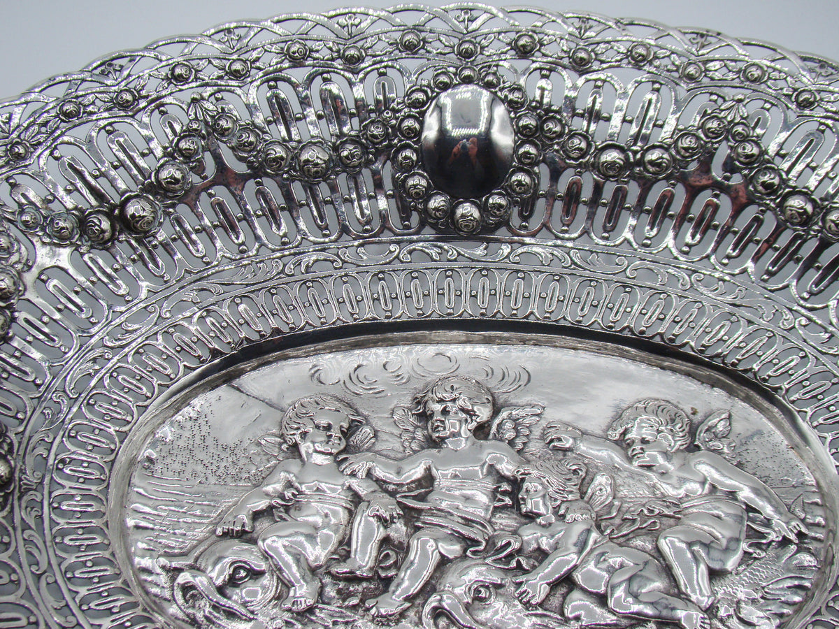 Upper border detail showing floral garlands, pierced silverwork and an oval cartouche