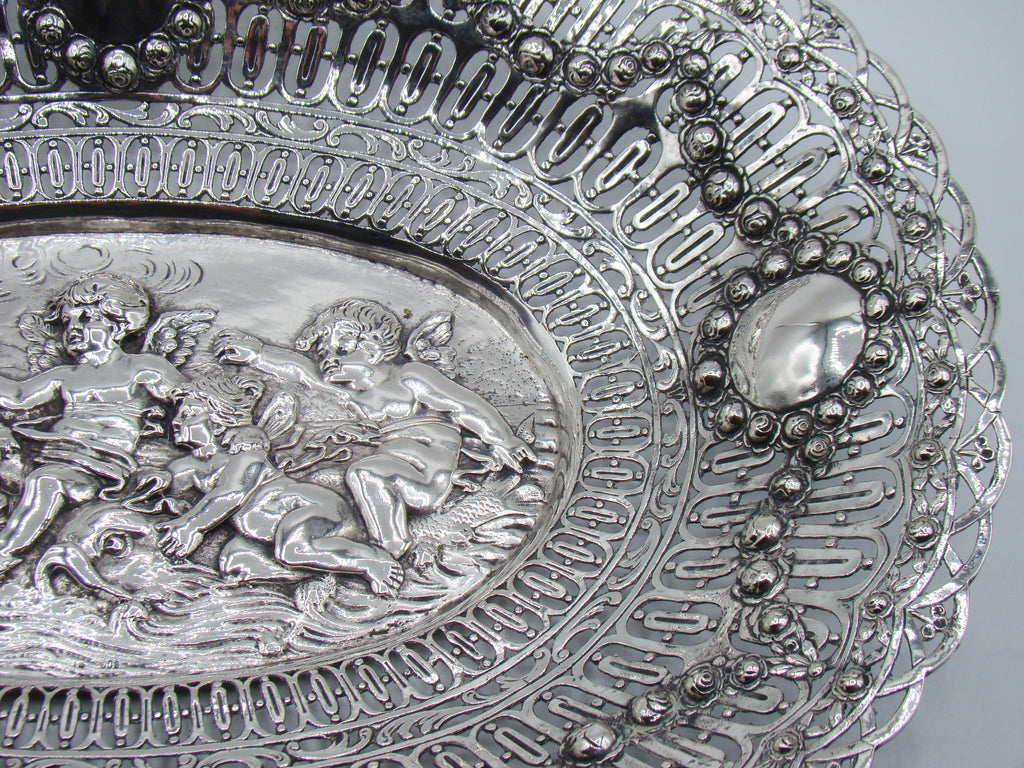 Right-hand detail of the silver tray showing a cherub and floral-framed oval cartouche