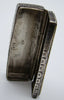Angled interior view of the open miniature silver box with a small stamped mark
