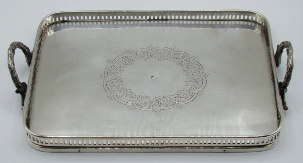 Silver tray with two decorative loop handles viewed lengthwise