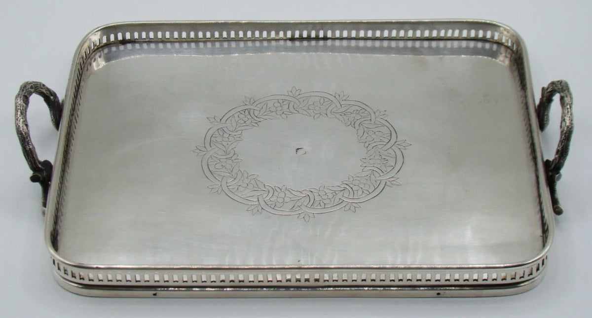 Silver tray with two decorative loop handles viewed lengthwise
