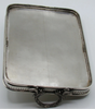 Underside of the silver tray showing a long linear surface mark