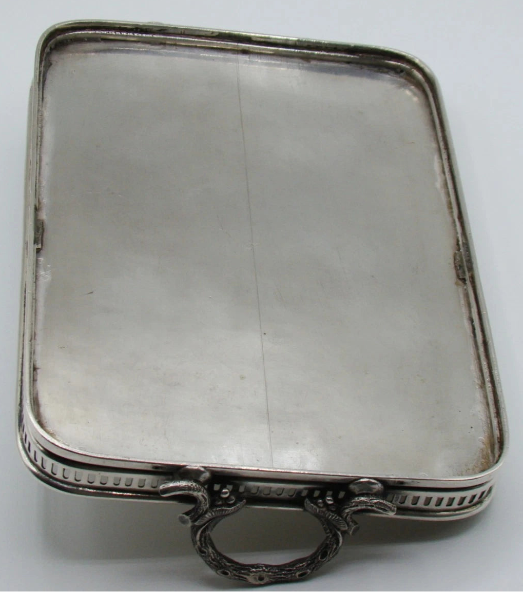 Underside of the silver tray showing a long linear surface mark