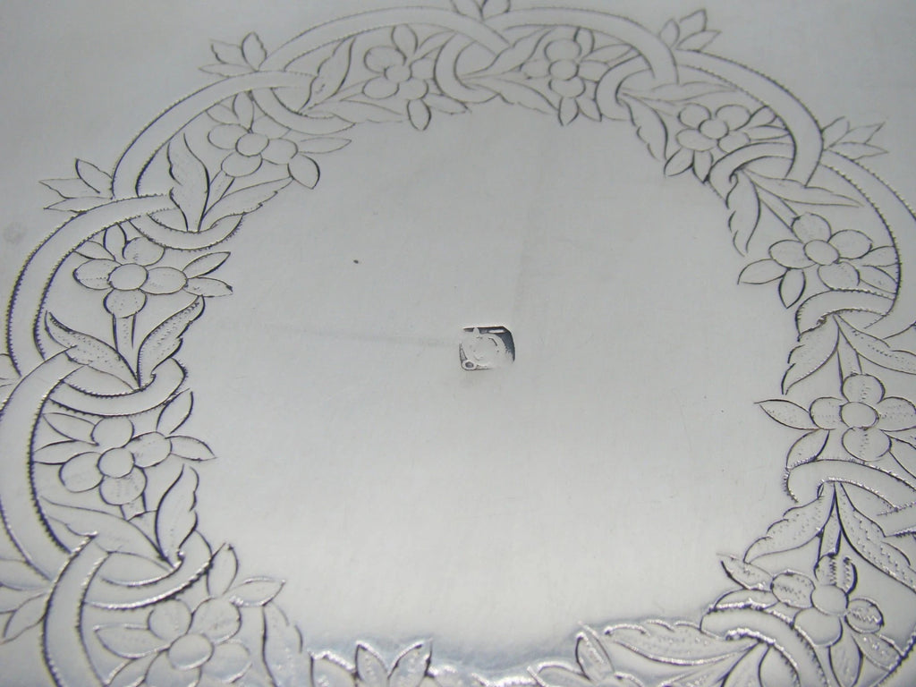 Close-up of stamped marks below the pierced gallery of the silver tray