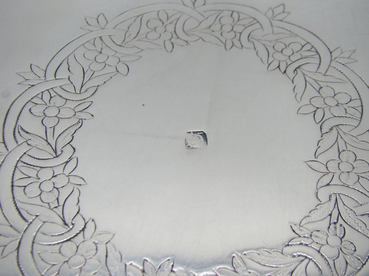Close-up of stamped marks below the pierced gallery of the silver tray