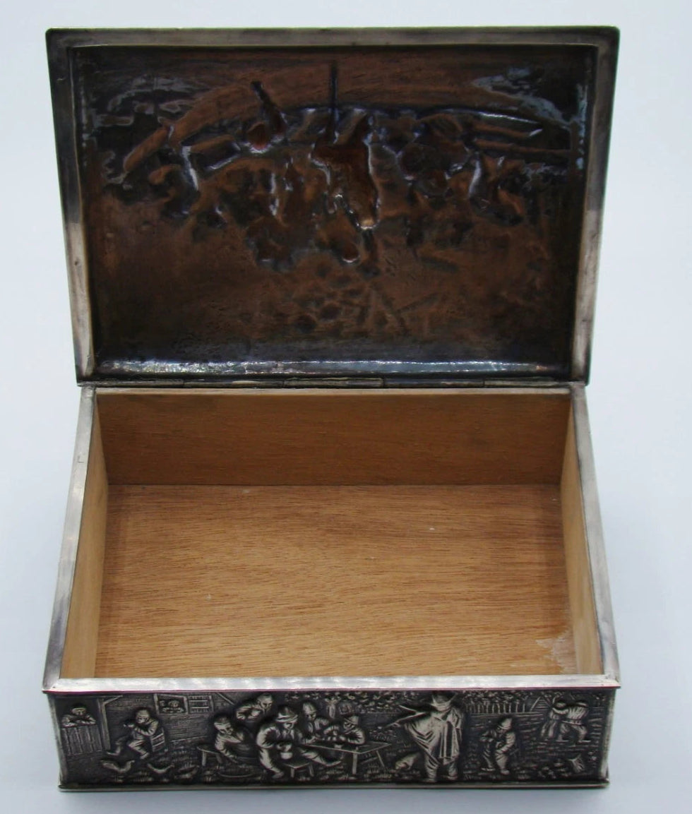 Silver box with lid open, showing its wooden-lined interior, hinge, and underside of the relief lid.