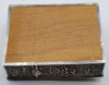 Wooden underside panel surrounded by the silver rim of the rectangular box.
