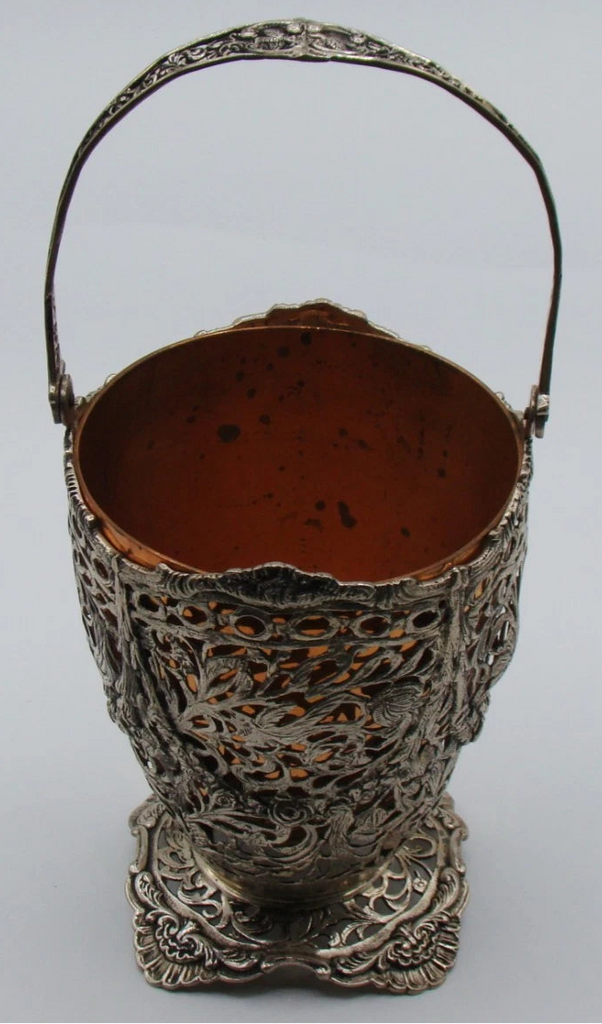 800 silver openwork basket with raised swing handle, shaped foot, and copper-coloured removable insert.