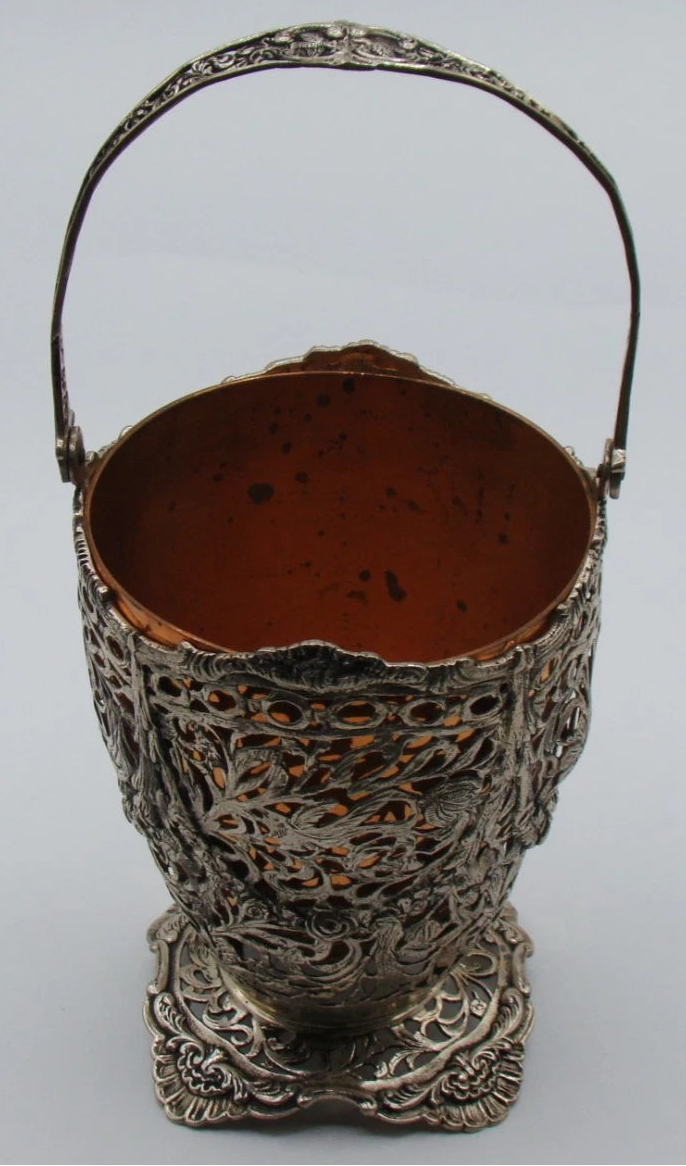 800 silver openwork basket with raised swing handle, shaped foot, and copper-coloured removable insert.