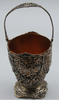 Front view of the silver basket with scalloped rim, scrolling foliage, and copper-coloured insert.