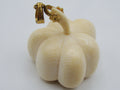 A small carved A small carved pumpkin-shaped pendant or charm in a warm ivory/creampendant or charm in a warm ivory/cream tone with a gold bail and loop at the top, photographed on a plain light background.