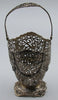 Silver basket without its insert, revealing the pierced foliate openwork and raised swing handle.