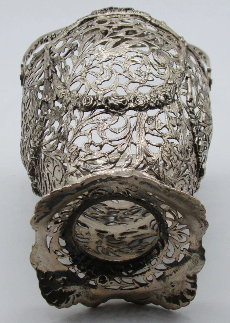 Underside and lower body of the silver basket showing the shaped pierced foot and scrolling decoration.
