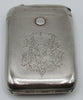 Front of 900 silver cigarette case with ornate engraved monogram, rounded corners, and round button.