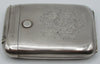 Horizontal view of the silver cigarette case showing the engraved monogram and narrow hinged compartment.