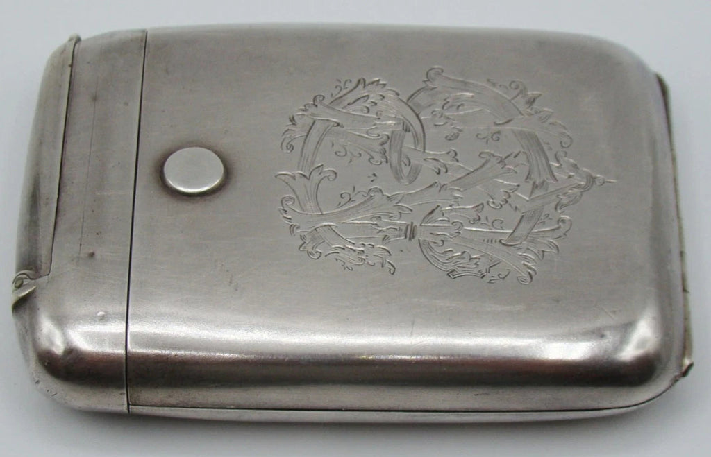 Horizontal view of the silver cigarette case showing the engraved monogram and narrow hinged compartment.