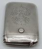 Upright view of the monogrammed silver case with its narrow compartment closed.