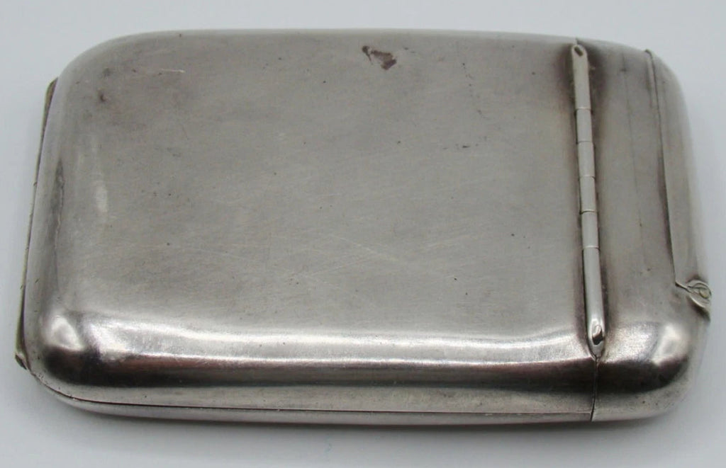 Plain reverse of the silver cigarette case showing surface marks and the narrow compartment hinge.