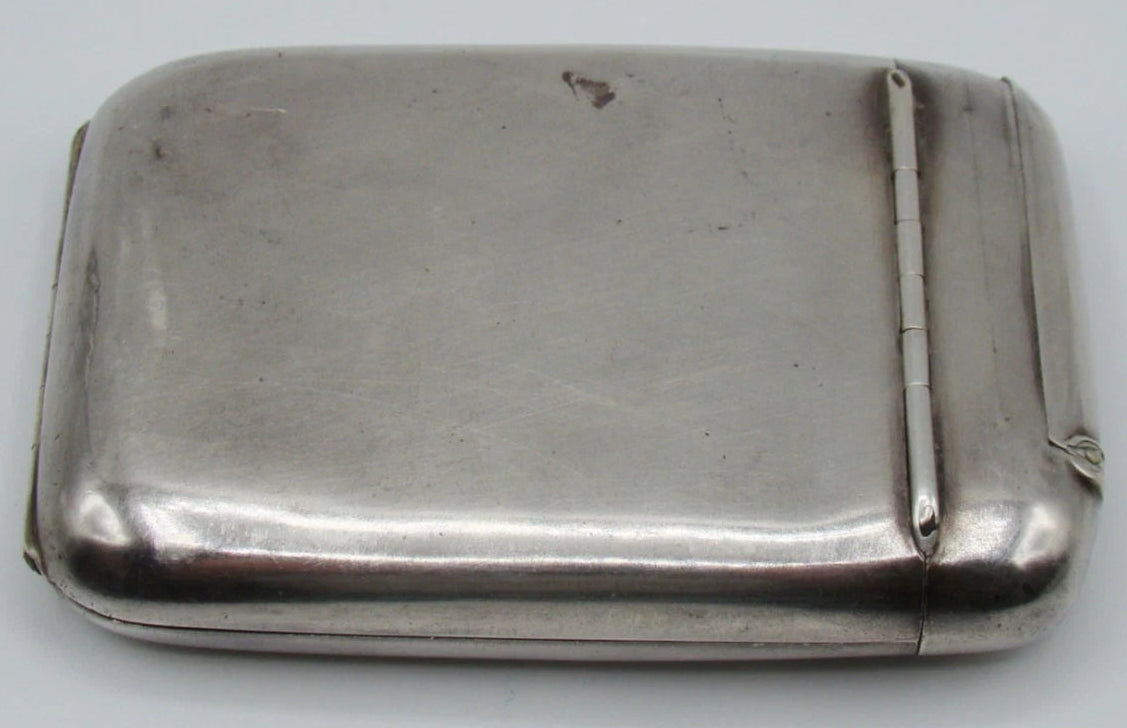 Plain reverse of the silver cigarette case showing surface marks and the narrow compartment hinge.