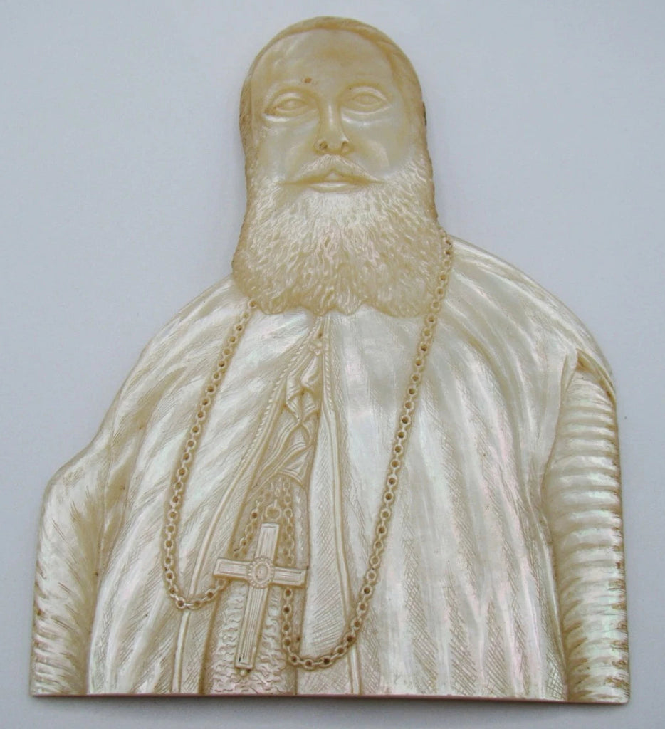 Close-up of the carved clerical portrait's face and textured beard in mother-of-pearl