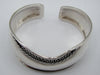 Top view of the silver cuff bracelet showing its open ends and shaped upper edge.