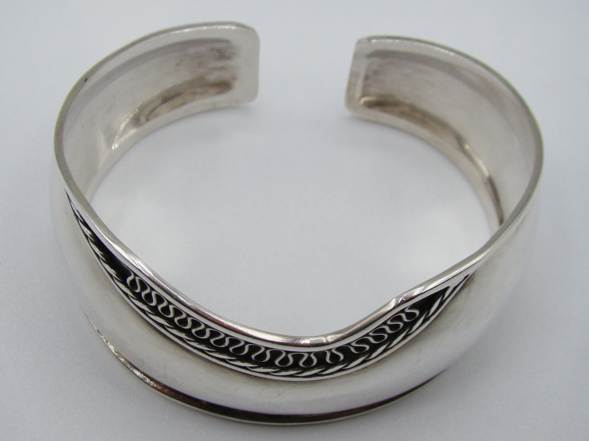 Top view of the silver cuff bracelet showing its open ends and shaped upper edge.
