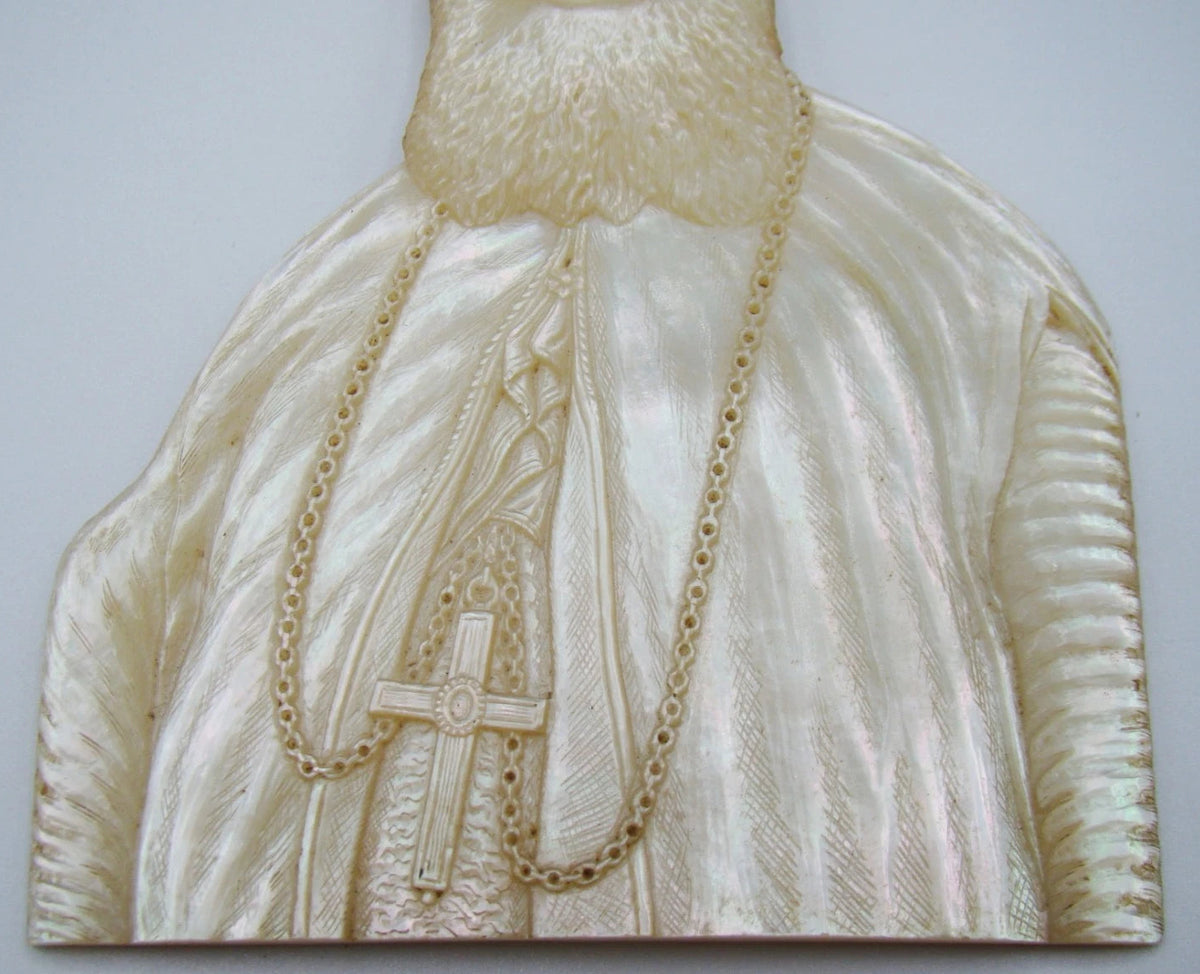 Reverse of carved shell portrait showing brown patches and an irregular line across the surface