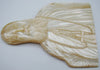 Sideways view of the mother-of-pearl bishop portrait showing the relief carving