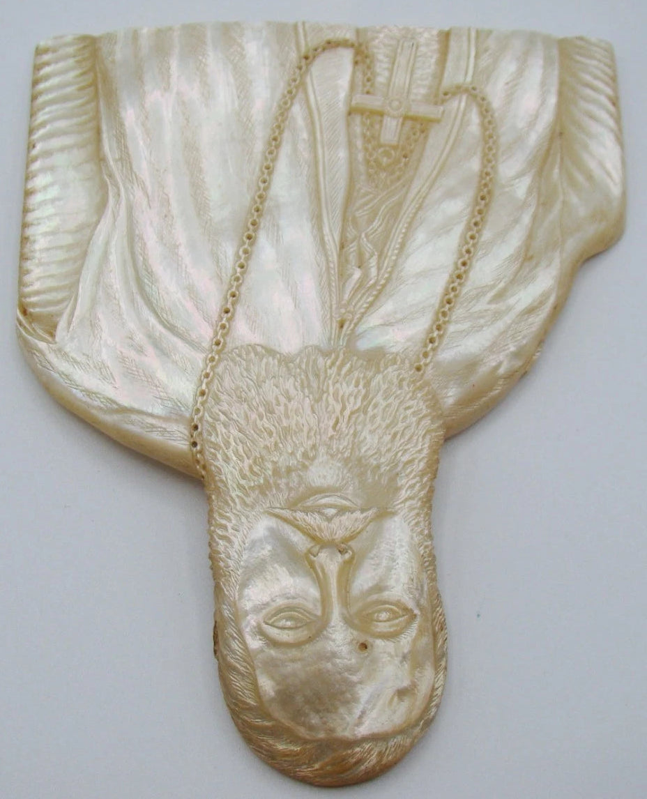 Opposite angled view of carved shell portrait with luminous robes and bearded face