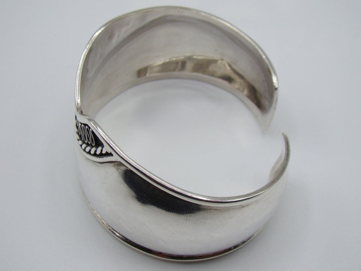 Side and interior view of the open silver cuff bracelet with its contoured edge.