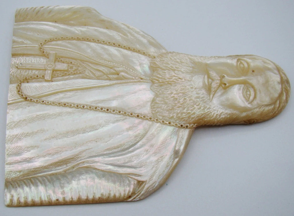 Full front view of mother-of-pearl carved bishop portrait with long beard, robes and pectoral cross