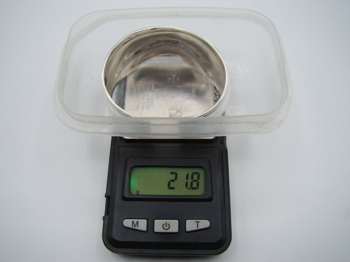 Silver cuff bracelet on a digital scale displaying 21.8 grams.