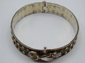 Silver hinged bangle with sculpted hand-motif fastening, round bird detail, and rope-like borders.
