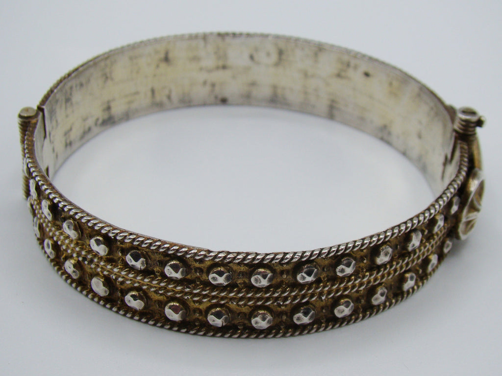 Rear view of the decorated silver bangle showing its hinge and twisted-wire horizontal bands.