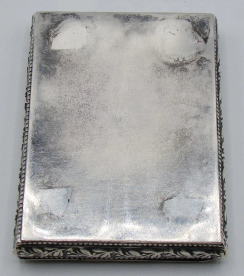Plain underside of the silver box showing scratches and patches of discolouration.
