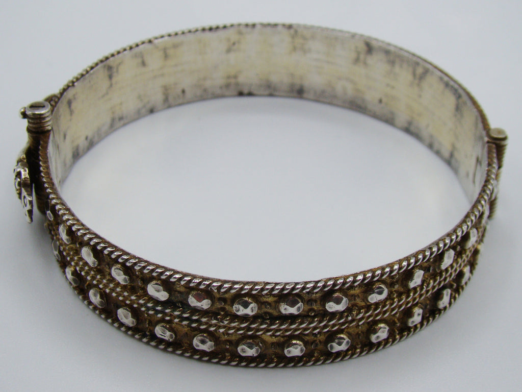 Top view of the silver bangle with hand-motif fastening and smooth curved interior.