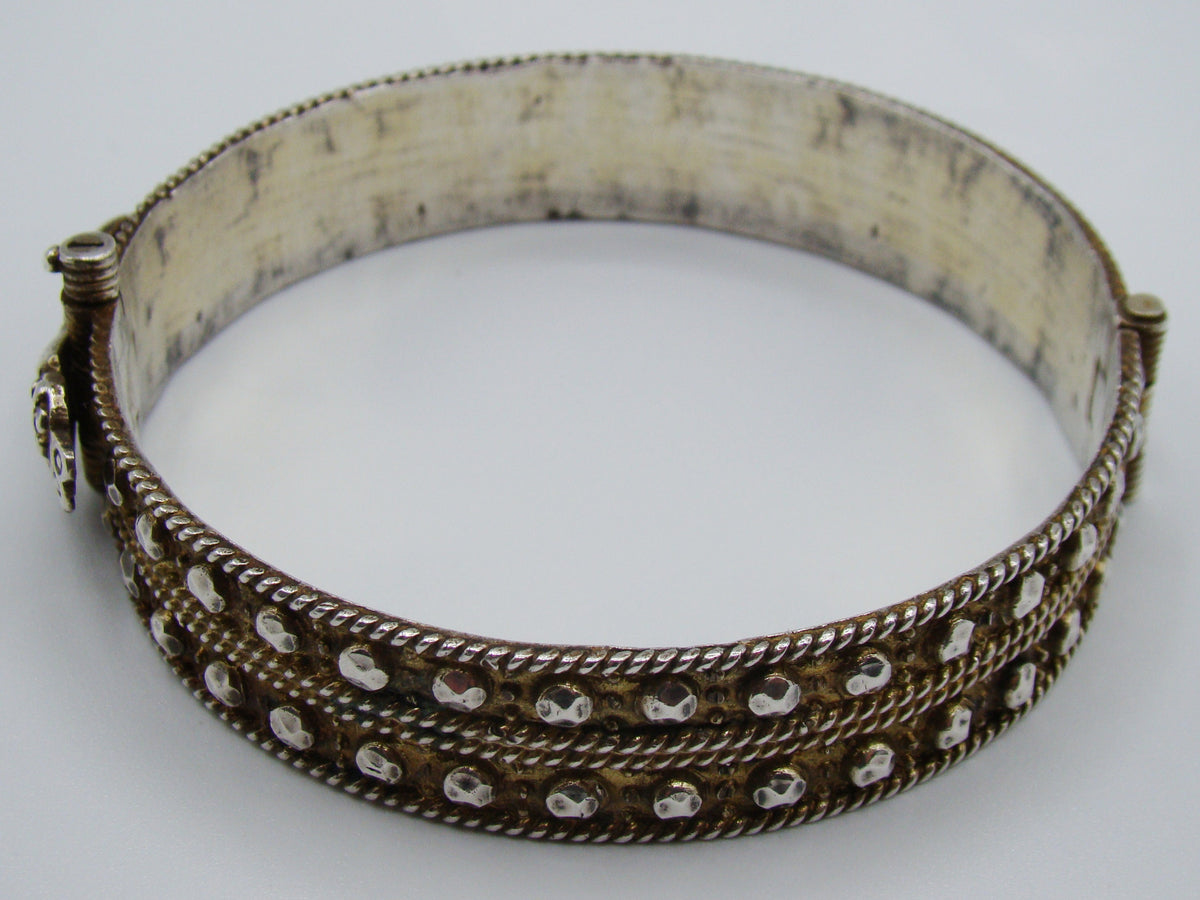Top view of the silver bangle with hand-motif fastening and smooth curved interior.