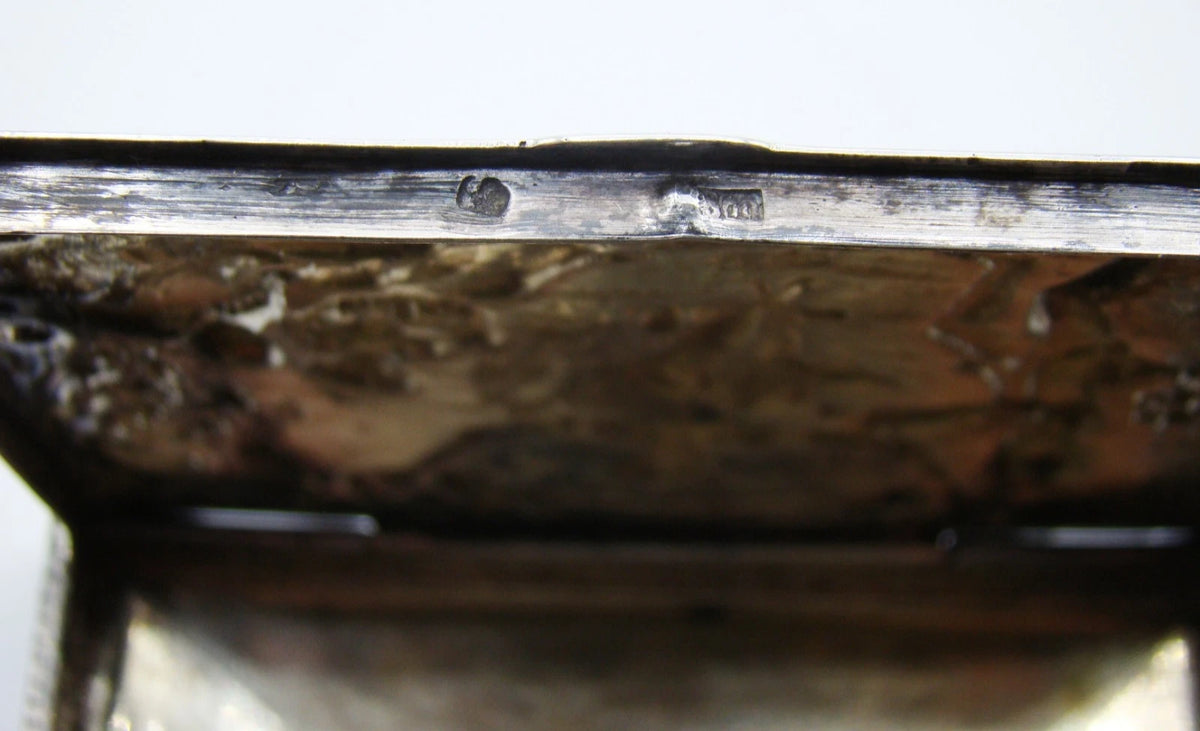 Silver relief box on a digital scale displaying 77 grams.